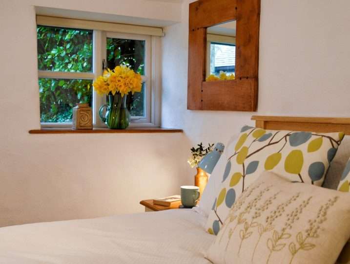 Cornish Barn Near Coast | Bedroom with daffodils in window