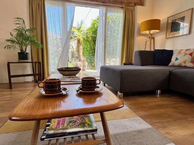 Cornish Barn Near Coast | Sitting room with coffee table & large patio doors