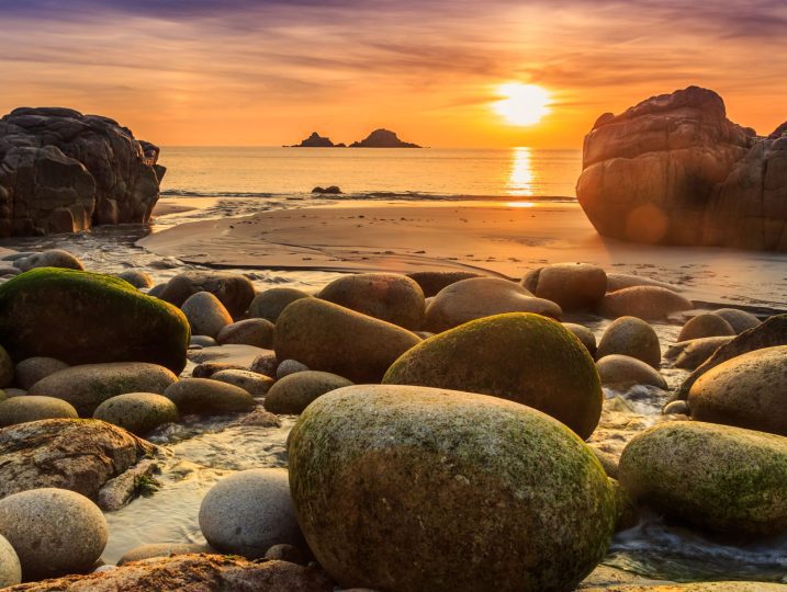 Porth Nanven Cove at sunset with dinosaur boulders in foreground | Cornish-Cottage-St-Just-Coastal
