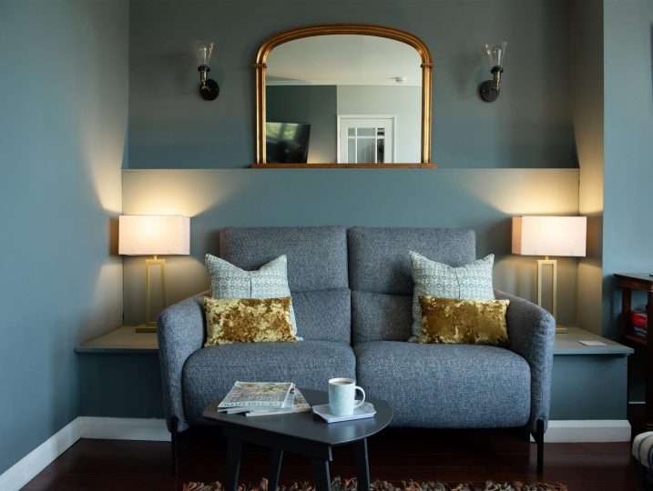 Stylish sitting room sofa with mirror behind | Retreat in Mousehole sea views